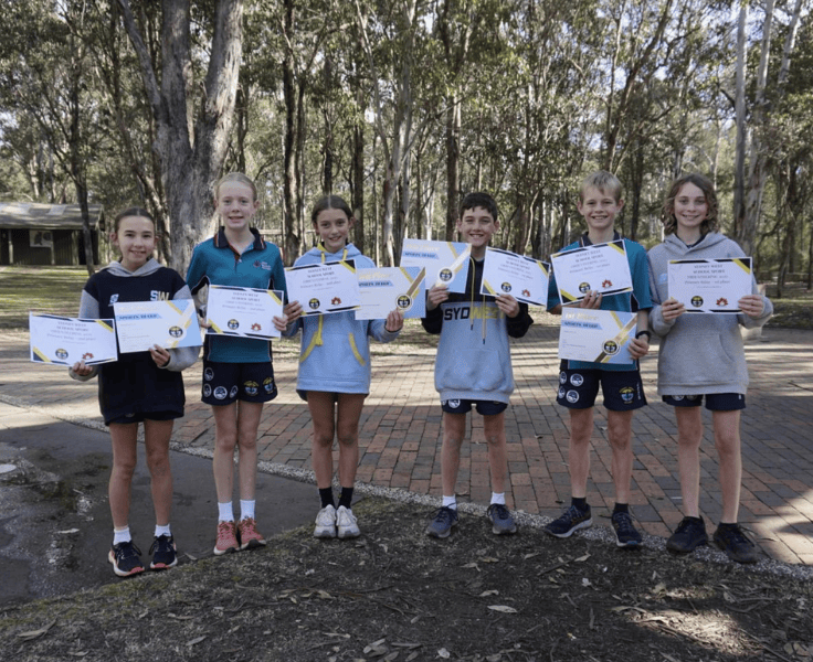 Six students in sports uniforms holding up certificated for orienteering
