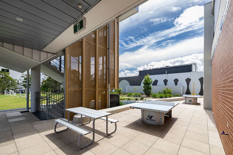 Outdoor recreational area with picnic tables and two large table tennis tables