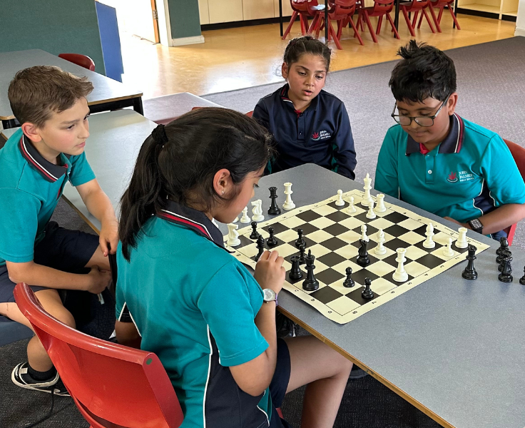 Four students playing chess