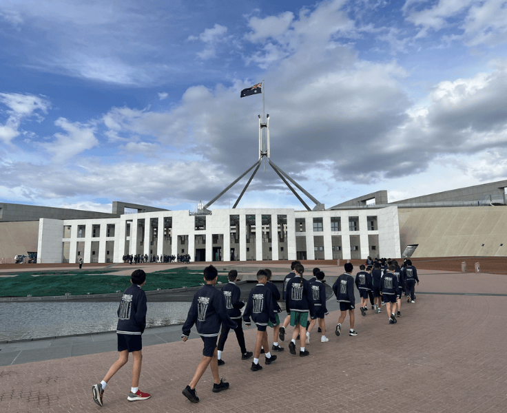A line of Year 6 students walking towards Canberra's Parliament House